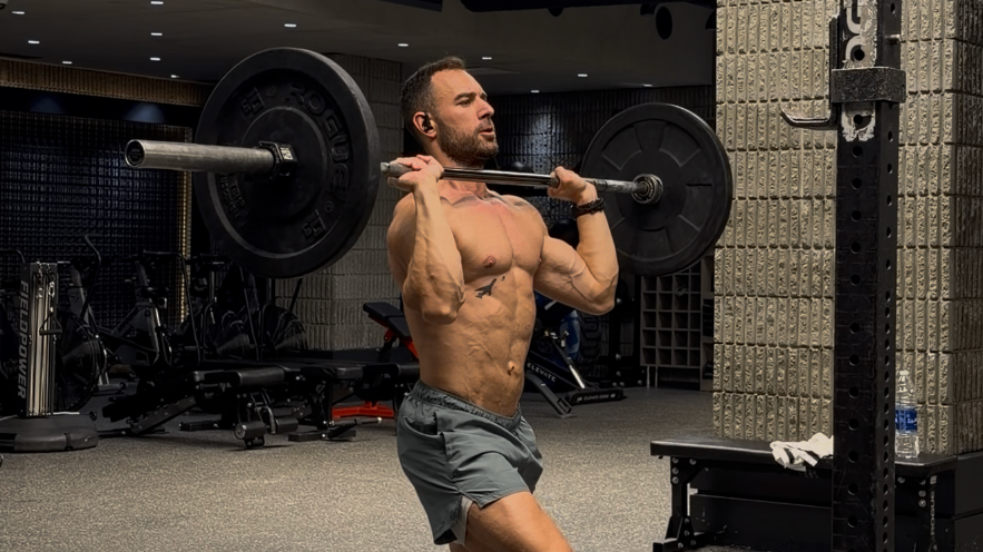 Chalked hands gripping a heavy steel barbell